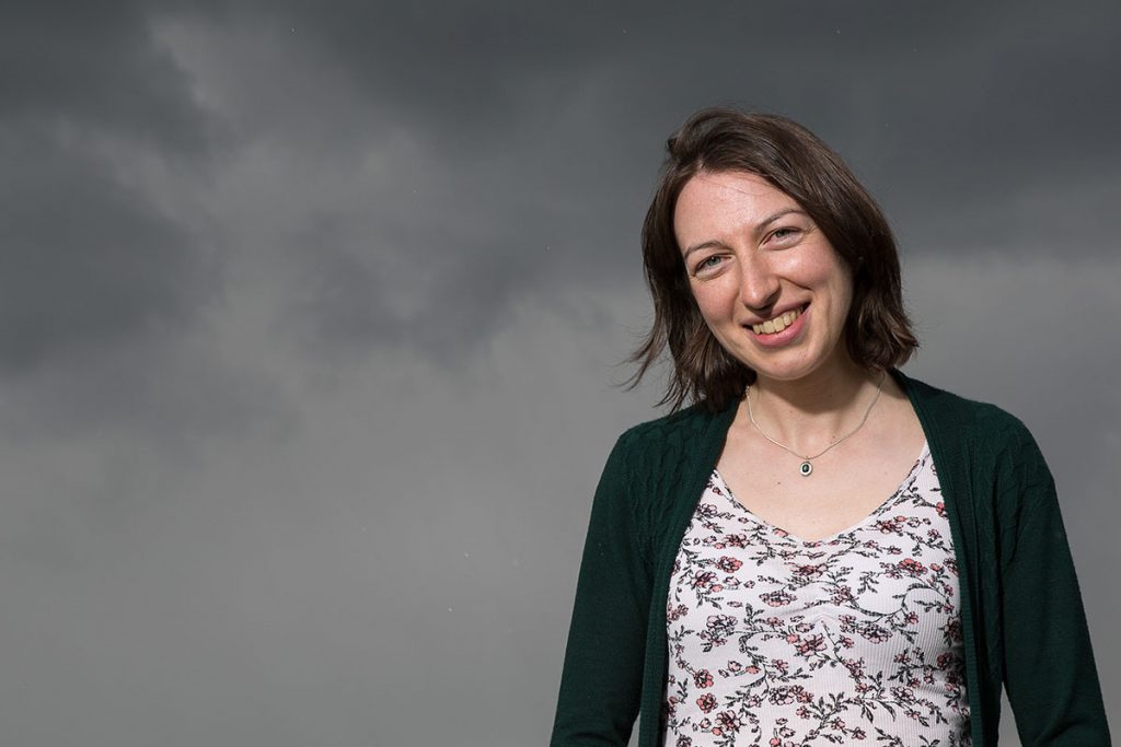 Headshot of professional photographer Karen Thorburn smiling in front of a dark sky