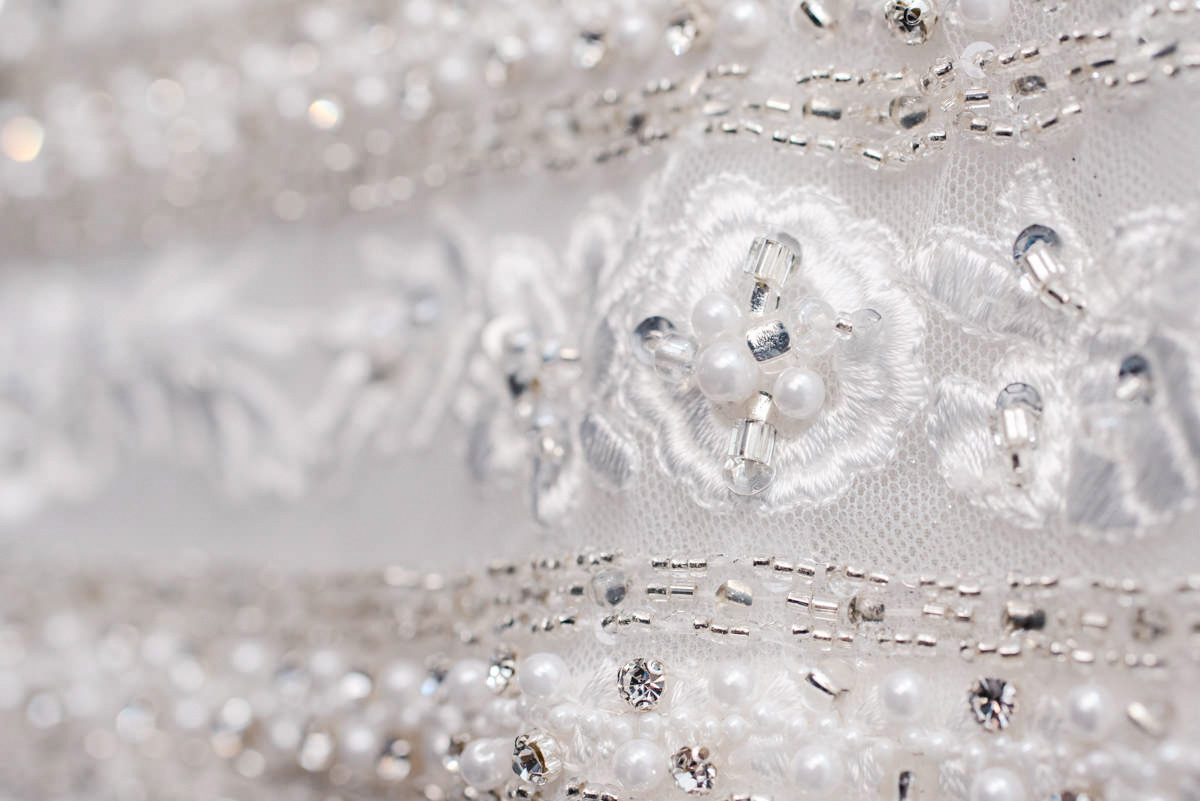 Sequins and lace in a straight and circular pattern on a white wedding dress