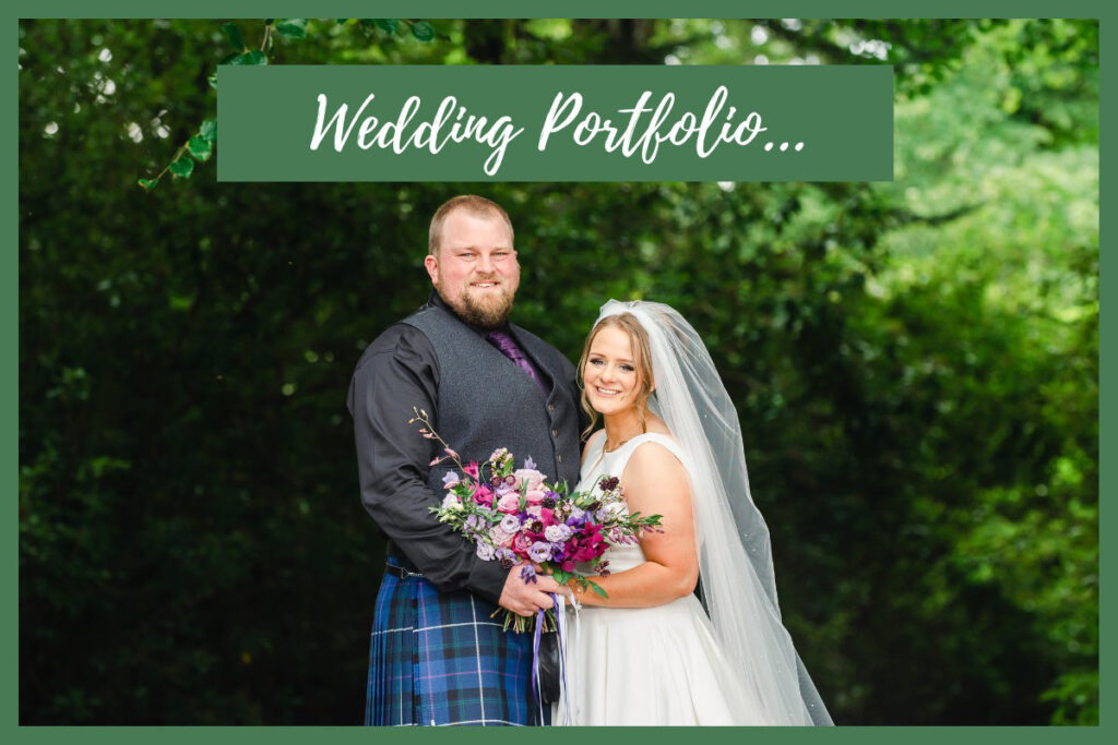 A bride in a white dress and a groom in a kilt holding pink and purple flowers and standing in front of green trees