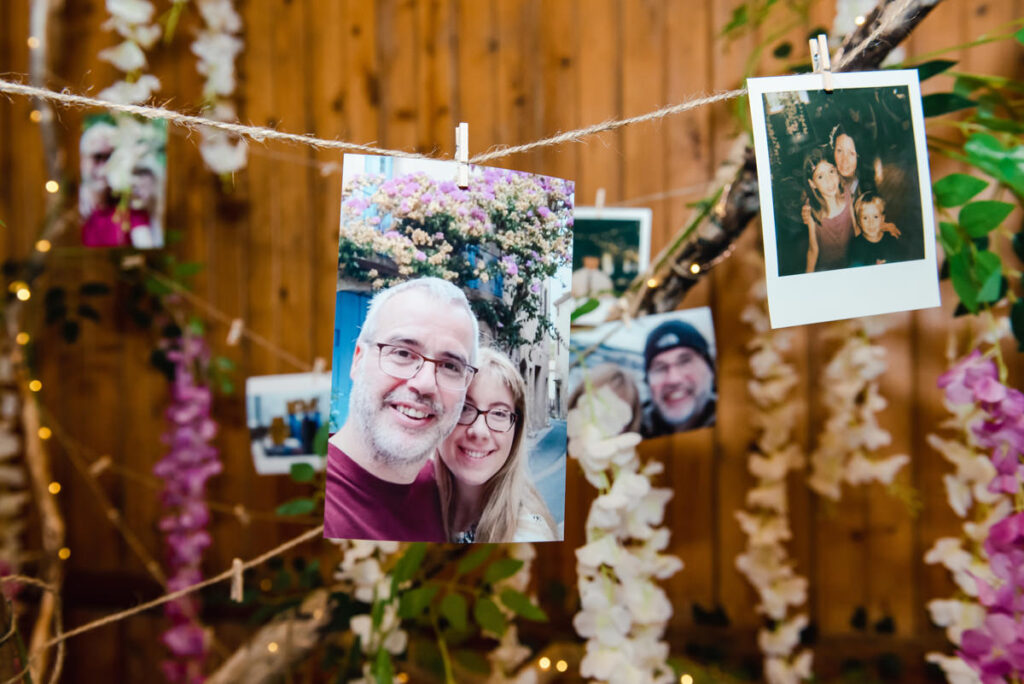 A photographic print of a man and woman pegged to a string in front of flowers and wooden walls